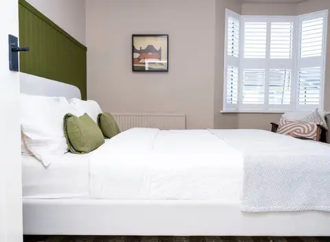 Double bedroom with shutters and green panelling