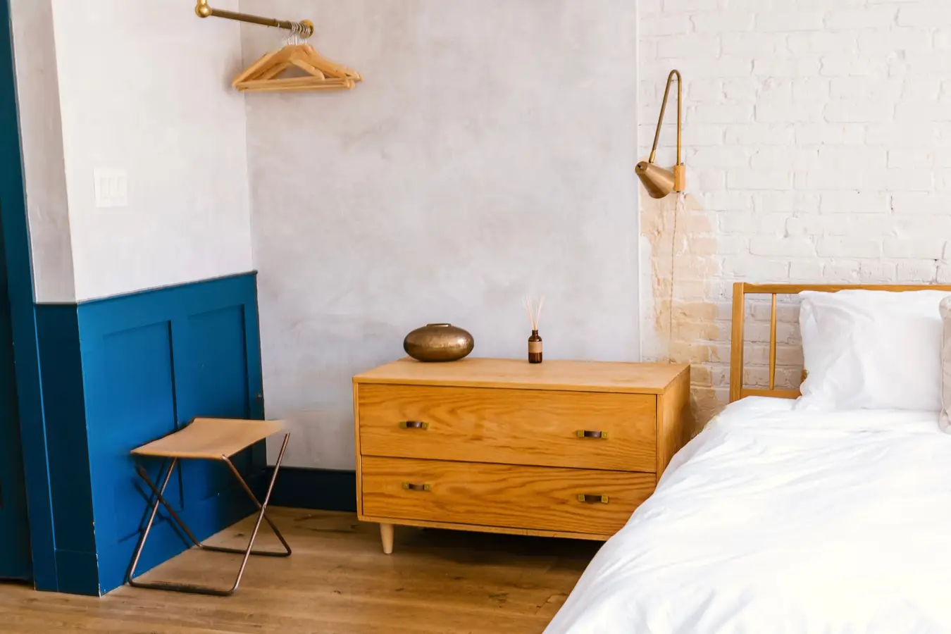 A bright bedroom with an oak bed and chest of drawers