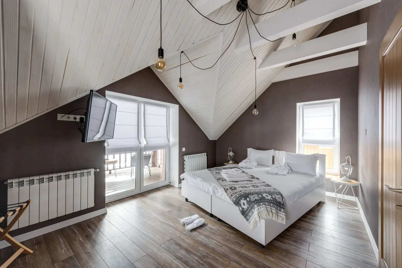 An attic bedroom set with towels, robes and slippers