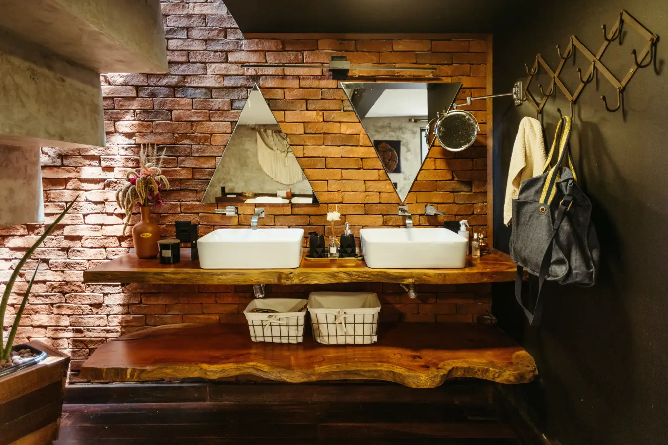 A double basin on a timber shelf against a brick wall
