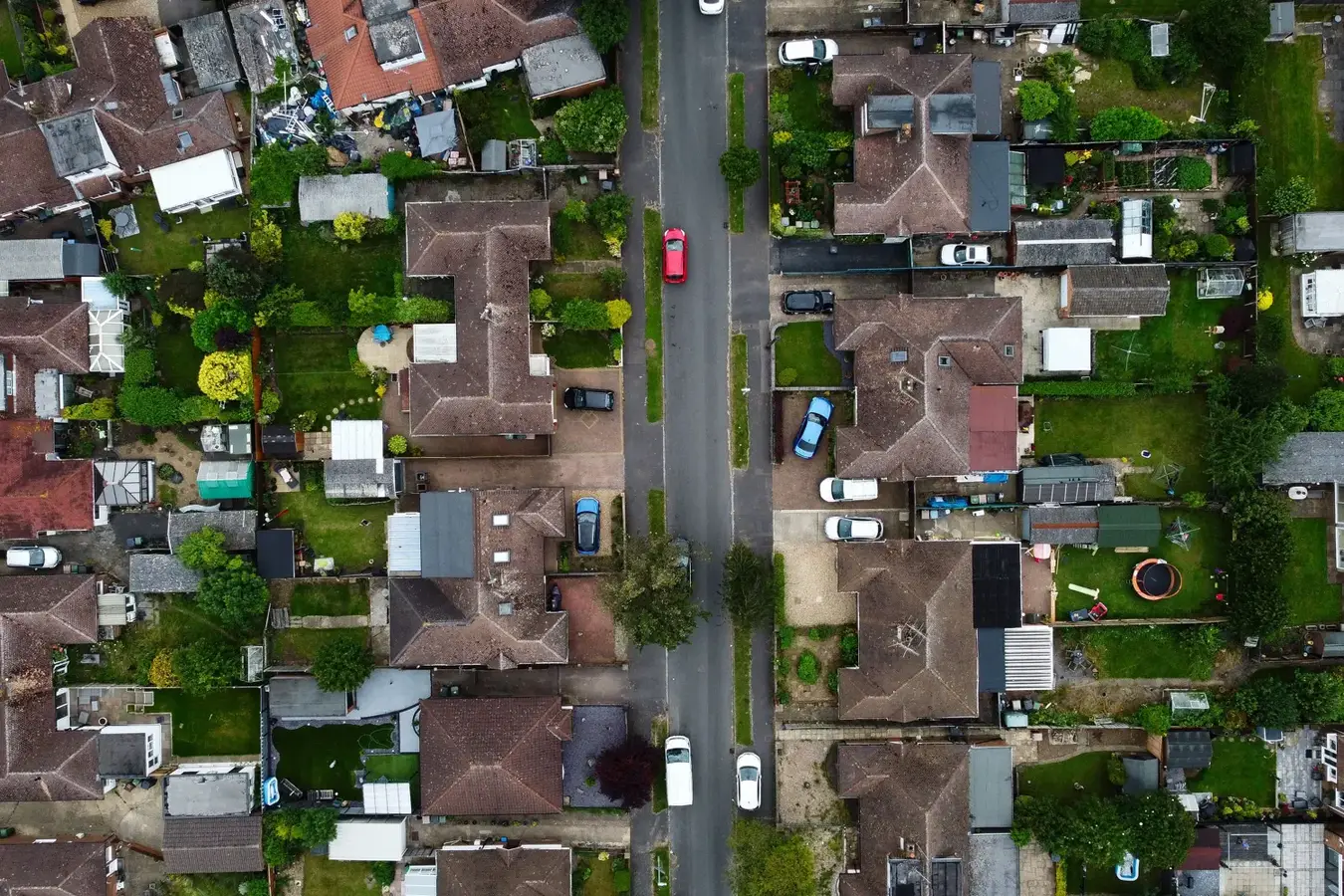 A residential street of houses and gardens seen from above