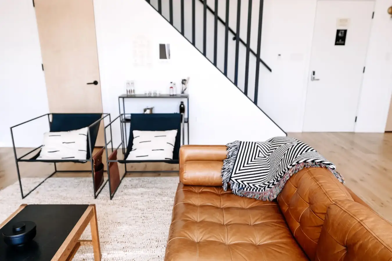 A bright living room with a leather sofa, set up for guests